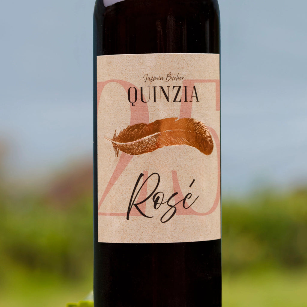 Nahaufnahme einer Flasche Quinzia Rosé mit dem handgestalteten Etikett.